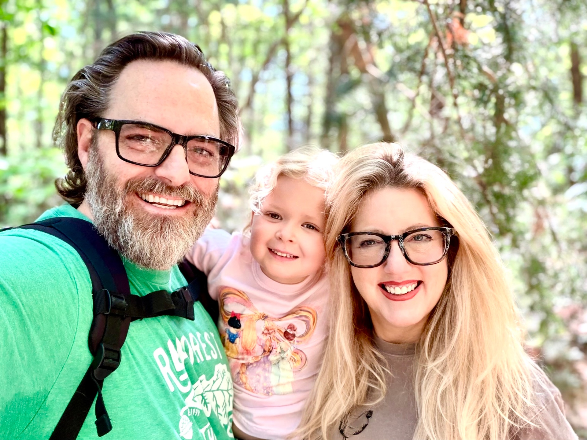 Tim and Sandi with their daughter on a forest hike
