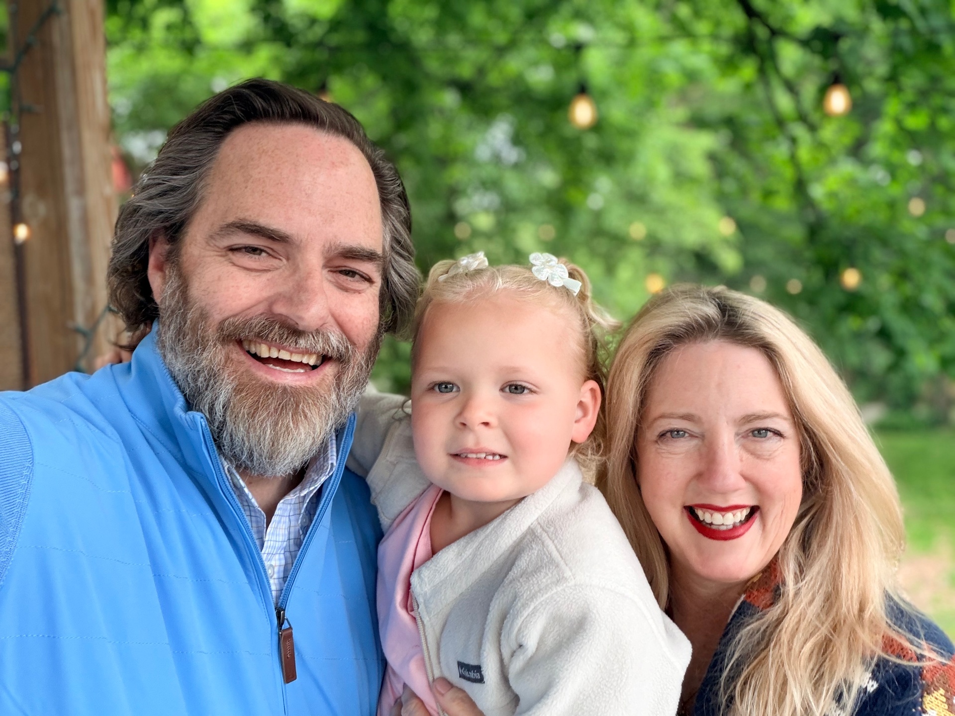 The Savage family in a garden with string lights